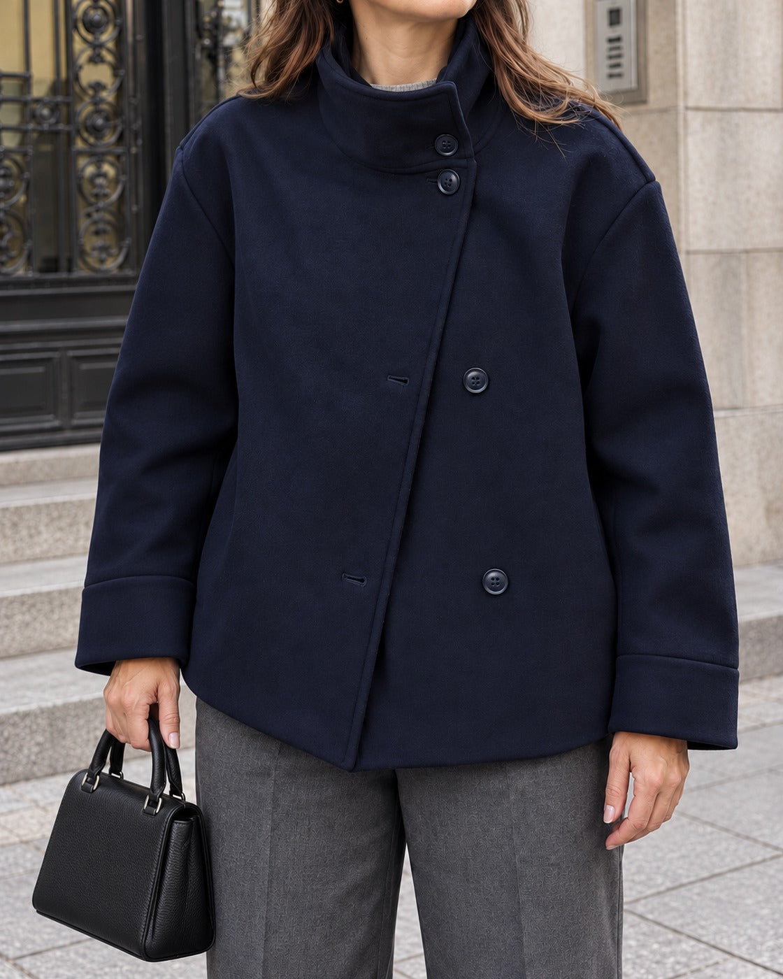 Margit – Sötétkék rövid kabát tölcsérgallérral és gombos záródással, modellen.